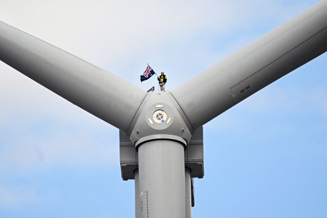 Australian businessman Andrew Twiggy Forrest waves an Australian flag as he stands on top of a wind turbine during the opening of Squadron Energy's Bango Wind Farm in Boorowa, Australia 28 April 2023. (Photo by Lukas Coch/EPA)