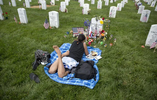 Laureen Lopez Berry lies on at her husband's grave on Memorial Day in section 60 at Arlington National Cemetery in Arlington, Va., Monday, May 30, 2016. Lopez Berry's husband, Army Staff Sgt. Richard Liam Berry, died July 22, 2012, while serving during Operation Enduring Freedom in Zharay, Afghanistan. (Photo by Carolyn Kaster/AP Photo)