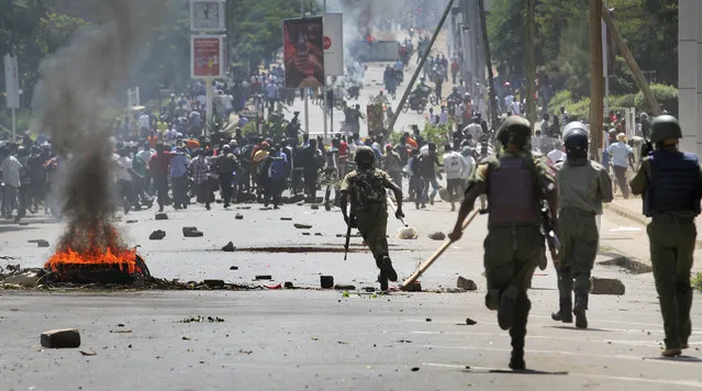 Riot police chase protesters calling for the disbandment of the national electoral commission over allegations of bias and corruption, in Kisumu, Kenya Monday, June 6, 2016. (Photo by James Keyee/AP Photo)