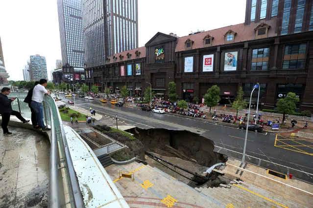 People look at the part of road that collapsed in Nantong, Jiangsu province, China June 10, 2017. Picture taken June 10, 2017. There are no casualties and the cause of collapse is under investigation, local media reports. (Photo by Reuters/Stringer)