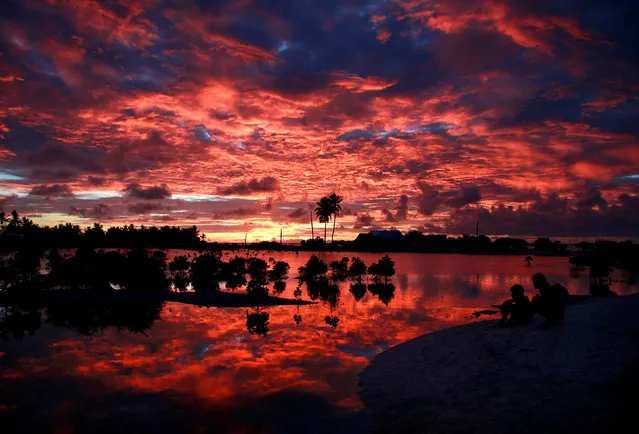 Villagers watch the sunset over a small lagoon near the village of Tangintebu on South Tarawa in the central Pacific island nation of Kiribati May 25, 2013. (Photo by David Gray/Reuters)