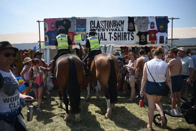 Mounted police officers mix with revellers at a merchandise stall during the Glastonbury Festival of Music and Performing Arts on Worthy Farm near the village of Pilton in Somerset, South West England, on June 21, 2017. (Photo by Oli Scarff/AFP Photo)