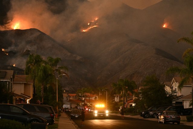 The Airport Fire burns in the hills above homes in Rancho Santa Margarita, California, on September 9, 2024. Wildfires fueled by soaring temperatures in the western United States have scorched thousands of acres, forcing hundreds of families to flee, US officials said September 9, 2024. (Photo by Patrick T. Fallon/AFP Photo)