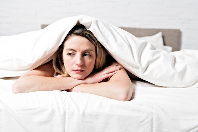 A unhappy mature female in bed at bedroom. (Photo by Alamy Stock Photo)