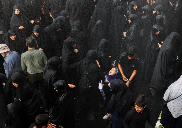 A girl reacts as it rains during the funeral procession of assassinated Hamas chief, Ismail Haniyeh in Tehran, Iran, on August 1, 2024. (Photo by Majid Asgaripour/WANA (West Asia News Agency) via Reuters)