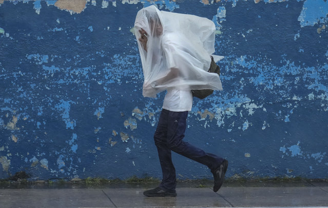 A man walks through the wind and rain brought by Hurricane Rafael in Havana, Cuba, Wednesday, November 6, 2024. (Photo by Ramon Espinosa/AP Photo)