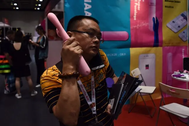 A visitor listens to an adult s*x toy during the Asia Adult Expo in Hong Kong on August 30, 2017. (Photo by Anthony Wallace/AFP Photo)