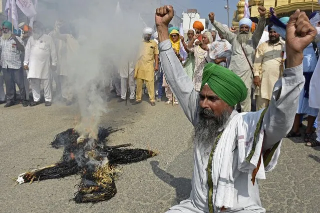Farmers shout slogans next to a burnt effigy of central government during a protest against the Electricity Amendment Bill 2022 on the outskirts of Amritsar on August 8, 2022. (Photo by Narinder Nanu/AFP Photo)