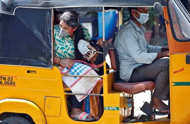 A dog wearing a protective mask is seen with its owner inside an autorickshaw during a 21-day nationwide lockdown to limit the spreading of coronavirus disease (COVID-19) in Chennai, India, March 30, 2020. (Photo by P. Ravikumar/Reuters)