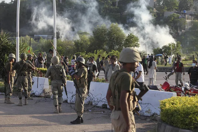 Pakistani paramilitary troops stand guard during a clash between police and protesters in Islamabad, Pakistan, Monday, September 1, 2014. Anti-government protesters stormed Pakistan's state television building Monday, forcing the channel briefly off the air as they clashed with police and pushed closer to the prime minister's residence. The violence comes as part of the mass demonstrations led by cleric Tahir-ul-Qadri and opposition politician Imran Khan that demand Prime Minister Nawaz Sharif resign. (Photo by Anjum Naveed/AP Photo)