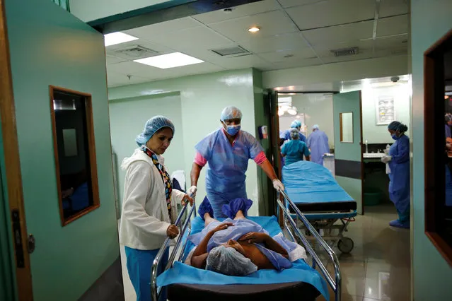 Medical personnel move a woman after her sterilization surgery in the operating room of a hospital in Caracas, Venezuela July 27, 2016. (Photo by Carlos Garcia Rawlins/Reuters)