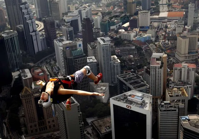 Franch base jumper Florian Pays gestures while leaping from Malaysia's landmark, 1,389-foot high KL Tower in Kuala Lumpur, on September 29, 2012. (Photo by Vincent Thian/Associated Press)