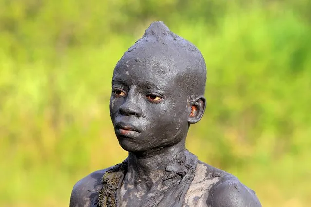 A Bukusu youth stands covered in mud in preparation for a circumcision ritual in Kenya's western region of Bungoma August 9, 2014. (Photo by Noor Khamis/Reuters)