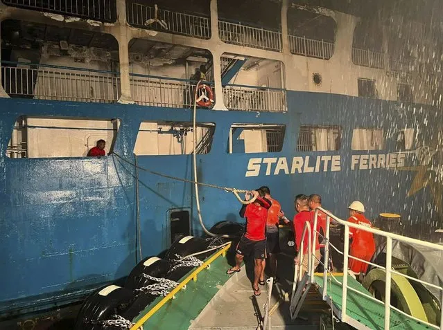 In this handout photo provided by the Philippine Coast Guard, Coast guard personnel help in controlling the fire of M/V Asia Philippines, an inter-island cargo and passenger vessel, they were riding caught fire while it was approaching Batangas port, southern Philippines on Friday. August 26, 2022. Philippine coast guard personnel and volunteers have rescued more than 80 passengers and crew of an inter-island ferry that caught fire as it approached a port south of Manila, prompting many to jump into the water as flames spread fast in windy weather, officials said Saturday. (Photo by Philippine Coast Guard via AP Photo)