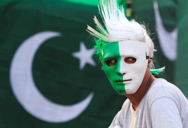 A vendor wears a mask with the colours of the Pakistani flag as people prepare to celebrate the country's Independence Day on August 14 at a roadside stall in Islamabad, Pakistan, August 10, 2016. (Photo by Faisal Mahmood/Reuters)