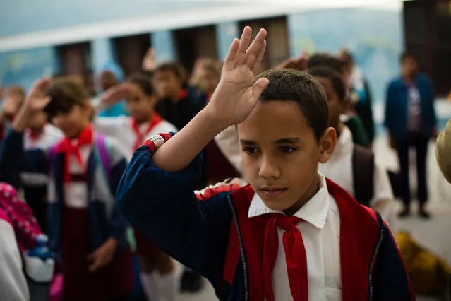 At Manuel Valdes Rodriguez Municipal Primary School in Havana, Cuba, fifth grader, Cristian Gongora, 10, shows his patriotism by saluting the flag and singing the national anthem before going to his classroom in the morning. (Photo by Sarah L. Voisin/The Washington Post)