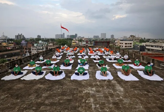 Staff members of a hospital, wearing protective face masks, perform yoga on the rooftop of their hospital building during International Yoga Day, in Kolkata, India, June 21, 2020. (Photo by Rupak De Chowdhuri/Reuters)