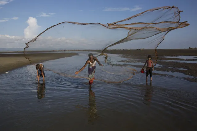 In this September 21, 2017 photo, a local fisherman throws a fishing net in Shah Porir Dwip, an island by the Bay of Bengal at Bangladesh’s southern tip. (Photo by Bernat Armangue/AP Photo)