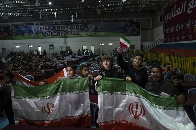 Palestinians wave Iranian flags as they watch a live broadcast of the World Cup soccer match between Iran and the United States played in Qatar in Gaza City, Tuesday, November 29, 2022. (Photo by Fatima Shbair/AP Photo)