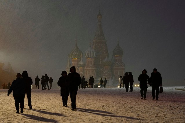 People walk in a snowy Red Square with the St. Basil's Cathedral, background center, during snowfall in Moscow, Russia, Tuesday, April 8, 2025, at temperatures around –1 degrees Celsius (30,2 Fahrenheit). (Photo by Alexander Zemlianichenko/AP Photo)