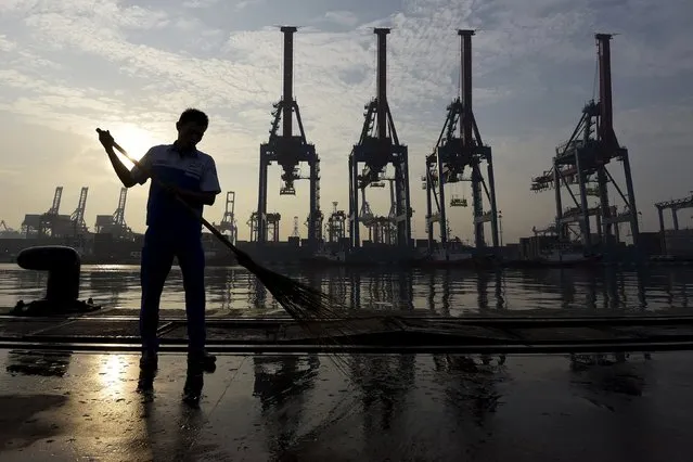 A worker sweeps part of the port at the Jakarta International Container Terminal (JICT), in Tanjung Priok, north Jakarta May 15, 2015 in this photo taken by Antara Foto. (Photo by Sigid Kurniawan/Reuters/Antara Foto)