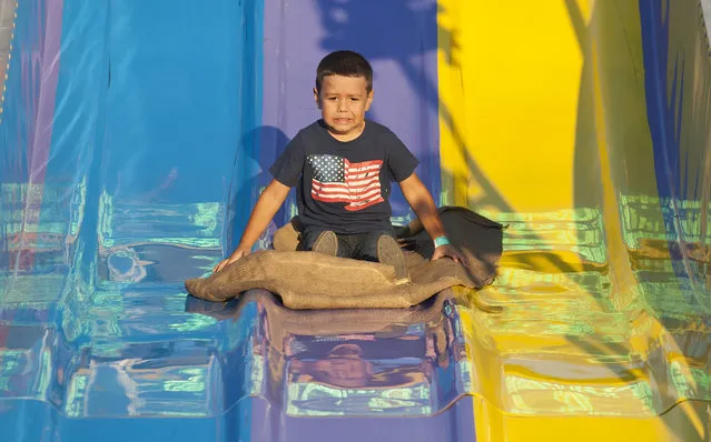 Aaron Vasquez, 4, of Grand Prairie rides a slide at the East Texas State Fair in Tyler, Texas, Thursday, October 1, 2015. The fair closes Sunday night. (Photo by Sarah A. Miller/The Tyler Morning Telegraph via AP Photo)