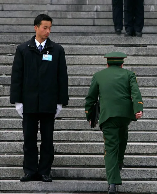 A military delegate (R) arrives at the Great Hall of the People for the fourth plenary session of the National People's Congress, or parliament in Beijing, China.  (Photo by Guang Niu)