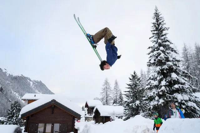 Teenager Luc makes a backflip on skis in the small resort of Zinal, Swiss Alps on January 9, 2018, after the access road which was cut by heavy snowfall reopened. Heavy snowfall has cut off many villages and resorts across the Alps, trapping some 13,000 tourists at Zermatt, one of Switzerland's most popular ski stations, officials said. (Photo by Fabrice Coffrini/AFP Photo)