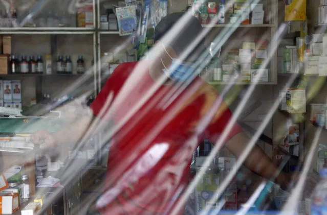 A drug store is covered with plastic sheet during lockdown in Kathmandu, Nepal, Tuesday, August 25, 2020. Nepal is in second lockdown after COVID-19 cases continued to rise in various parts of the nation along with capital city Kathmandu. (Photo by Niranjan Shrestha/AP Photo)