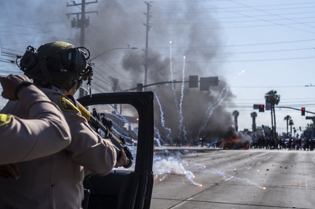 Law enforcement clashes with demonstrators during a protest following federal immigration operations, in the Compton neighborhood of Los Angeles, California on June 7, 2025. US President Donald Trump deployed 2,000 troops on June 7, 2025 to handle escalating protests against immigration enforcement raids in the Los Angeles area, a move the state's governor termed "purposefully inflammatory." Federal agents clashed with angry crowds in a Los Angeles suburb as protests stretched into a second night Saturday, shooting flash-bang grenades and shutting part of a freeway amid raids on undocumented migrants, reports said. (Photo by Ringo Chiu/AFP Photo)