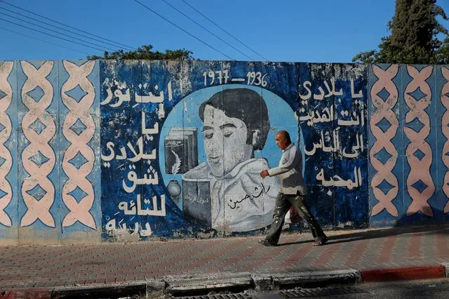 A man walks past a mural with writing in Arabic that reads, “My country, you gave us love and light which revealed paths for the lost” in the Israeli Arab city of Umm al-Fahm August 16, 2016. (Photo by Ammar Awad/Reuters)