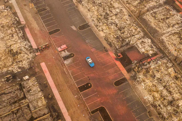 In this aerial view from a drone, a police patrol car drives by apartment homes destroyed by wildfire on September 12, 2020 in Talent, Oregon. Hundreds of homes in Talent and nearby towns have been lost due to wildfire. (Photo by David Ryder/Getty Images)