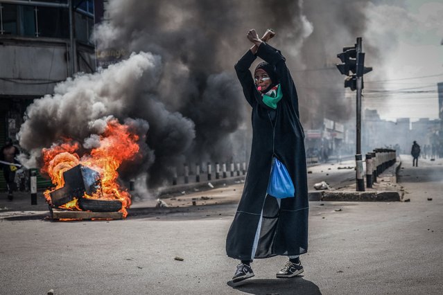 A protester reacts in front of a burning barricade in downtown Nairobi on June 25, 2025 during a planned day of protest marking the first anniversary of the storming of the parliament. Thousands of protesters took to Kenya's streets on Wednesday to mark a year since people stormed parliament at the peak of anti-government demonstrations, despite fears that they would be met by state-backed gangs and police violence. At least 60 people were killed last year by security forces in weeks of protests over tax rises and the dire economic situation for young Kenyans. Activists and families of victims have called for peaceful demonstrations to mark a year since the deadliest day of the unrest when parliament was invaded. (Photo by Luis Tato/AFP Photo)