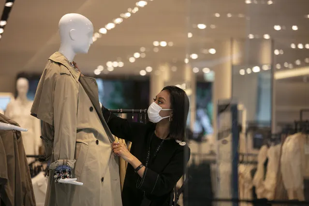 In this March 1, 2020, file photo, a department store employee with a mask dresses a mannequin in Tokyo. Japan’s economy shrank at annual rate of 27.8% in April-June, the worst contraction on record, as the coronavirus pandemic slammed consumption and trade, government data released Monday, Aug. 17, 2020, show. (Photo by Jae C. Hong/AP Photo/File)