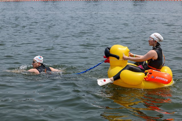 A competitor swims, with his partner connected with a duck-shaped tube, in the 1-km course of the Han River in Seoul, South Korea, 30 May 2025, part of the Seoul metropolitan government's triathlon competition to promote the river's improved water quality. (Photo by Yonhap/EPA)