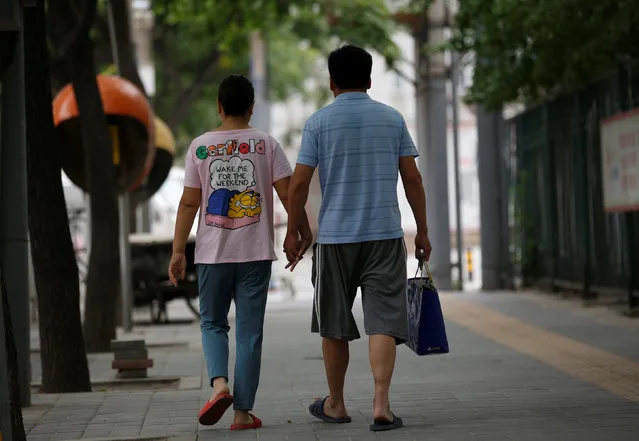 Wang and her husband Liu hold hands as they walk toward a hospital in Beijing, China, June 23, 2016. Wang, who suffers from cervical cancer, came from Inner Mongolia to seek treatment at a specialist hospital in Beijing. (Photo by Kim Kyung-Hoon/Reuters)