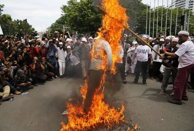 Members of a hardline Islamic group, the Islamic Defenders Front (FPI), burn an effigy of Jakarta Governor Basuki Tjahaja Purnama or Ahok, as they reject Ahok as their governor in front of Jakarta's city hall, December 1, 2014. (Photo by Reuters/Beawiharta)