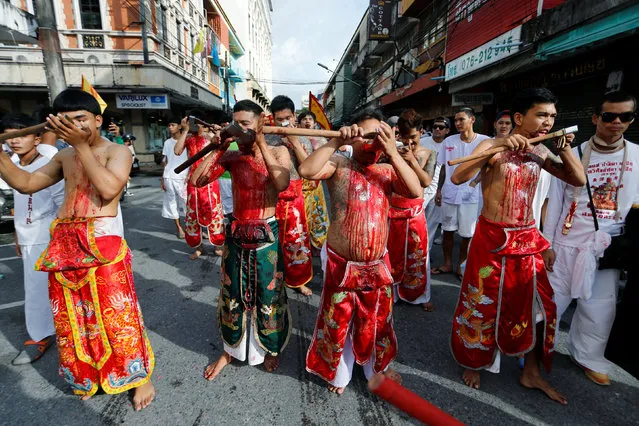 Devotees of the Chinese Samkong Shrine walk while cutting their tongues with axes during a procession celebrating the annual vegetarian festival in Phuket, Thailand October 4, 2016. (Photo by Jorge Silva/Reuters)