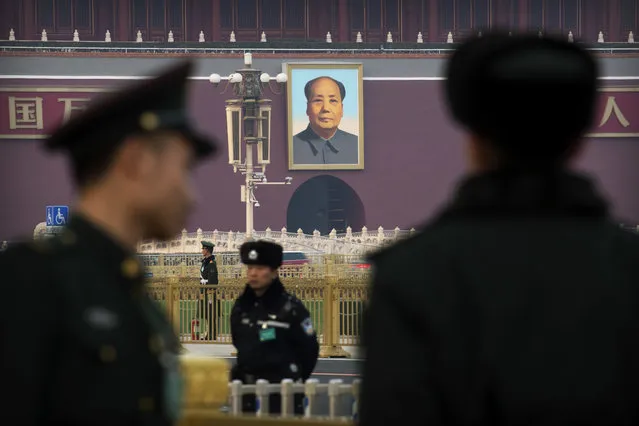 Security personnel stand guard outside of the Great Hall of the People near the portrait of Chinese leader Mao Zedong at Tiananmen Gate in Beijing, Friday, March 2, 2018. The annual meetings of China's top legislative bodies are set to begin on Saturday, during which the two-term limit on China's presidency is expected to be removed. (Photo by Mark Schiefelbein/AP Photo)