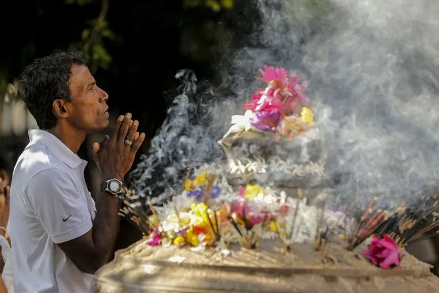 Sri Lankan Buddhist devotees take part in a religious observance on a full moon day at a temple in the Kelaniya suburb of Colombo, Sri Lanka, 07 November 2022. Buddhism is the official religion of the South Asian island nation and the majority of the island's population traditionally engages in religious observances on full moon days. (Photo by Chamila Karunarathne/EPA/EFE)