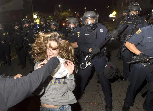A protester flees as police officers try to disperse a crowd comprised largely of student demonstrators during a protest against police violence in the U.S., in Berkeley, California early December 7, 2014. (Photo by Noah Berger/Reuters)
