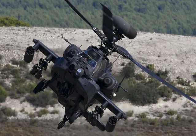 An AH-64 Apache helicopter takes part in Exercise Trident Juncture 2015, NATO's largest  joint and combined military exercise in more than a decade, at the San Gregorio training grounds outside Zaragoza, Spain, November 4, 2015. Some 36.000 personnel from more than 35 nations, including all NATO Allies  will have participated in Exercise Trident Juncture 2015 which began on 21 October, in Italy, Portugal and Spain, including their adjacent waters and airspace and runs till November 6. (Photo by Paul Hanna/Reuters)