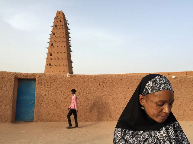 A man and woman walk in front of the Grand Mosque of Agadez, Niger, May 6, 2016. (Photo by Joe Penney/Reuters)