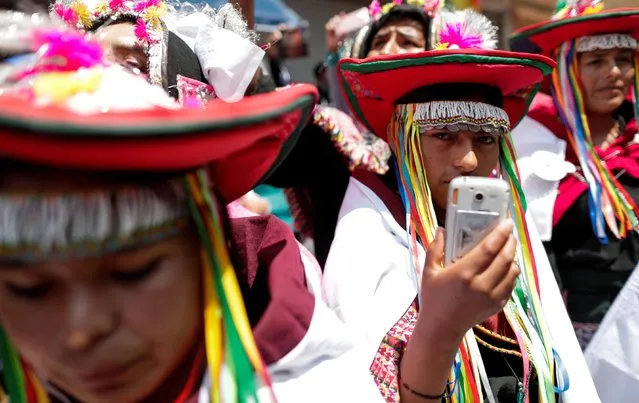An indigenous person holds a cell phone and looks on as former Bolivian President Evo Morales returns to his home country from exile in Argentina, at the border town of Villazon, Bolivia, November 9, 2020. (Photo by Ueslei Marcelino/Reuters)