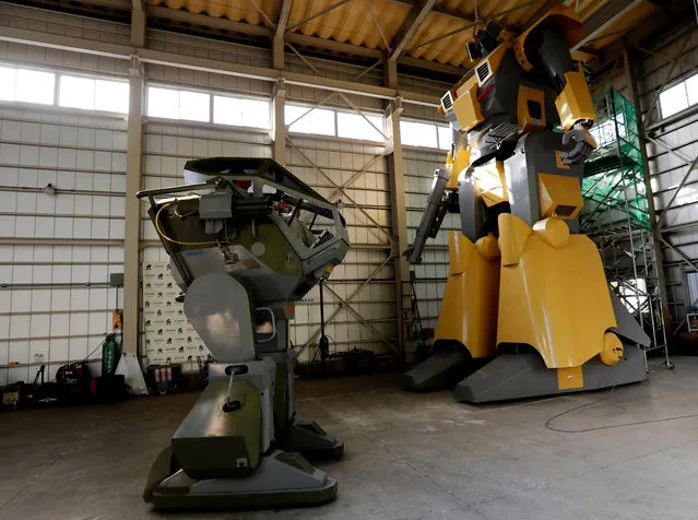 Sakakibara Kikai's engineer Masaaki Nagumo controls the bipedal robot Land Walker (L) next to Mononofu during its demonstration at its factory in Shinto Village, Gunma Prefecture, Japan on April 12, 2018. The company has created robots as varied as the Land Walker, the smaller Kid's Walker Cyclops and the MechBoxer boxing machine – but the mighty Mononofu towers over them all and executes more complex movements. (Photo by Kim Kyung-Hoon/Reuters)