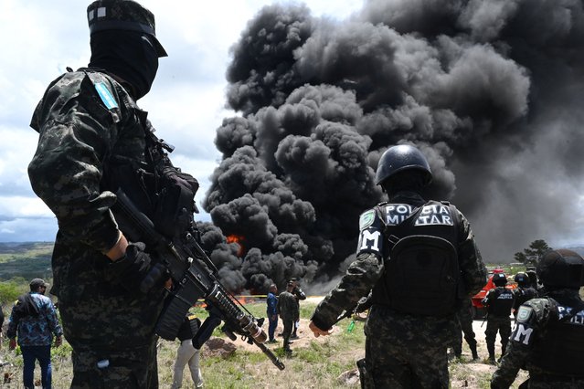 Members of the Honduran Military Police of Public Order stand guard during the incineration of 5.6 tonnes of cocaine in a military unit on the southern outskirts of Tegucigalpa on June 13, 2024. This is the second cocaine-burning operation in Honduras in 2024. On April 9, 1,350 kilos were confiscated and burned two weeks earlier by ten Hondurans detained on two boats in the jurisdiction of the insular department of Islas de la Bahia (Caribbean). (Photo by Orlando Sierra/AFP Photo)