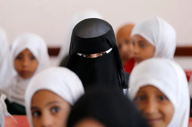 Girls attend a class in their school which was hit by Saudi-led air strikes last year, as schools open this week in Sanaa, the capital of war-torn Yemen October 5, 2016. (Photo by Khaled Abdullah/Reuters)