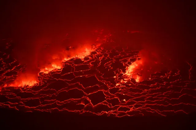 Lava is seen glowing inside the crater of the Nyiragongo volcano inside the Virunga National Park near the eastern Congolese city of Goma in the Democratic Republic of Congo, August 9, 2019. (Photo by Baz Ratner/Reuters)