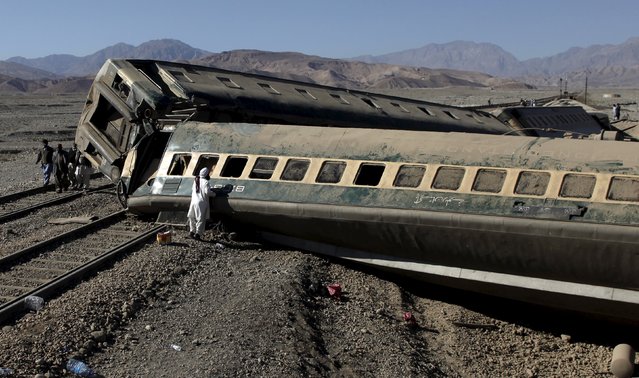 A passenger looks for his belongings after a train derailed in Quetta, Pakistan November 17, 2015. (Photo by Naseer Ahmed/Reuters)