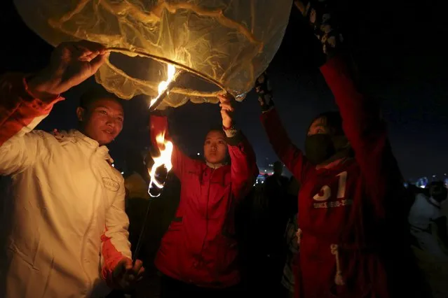 People light traditional home-made paper lanterns before releasing them into the sky, during the annual Tazaungdaing balloon festival in Taunggyi, Myanmar November 19, 2015. (Photo by Soe Zeya Tun/Reuters)